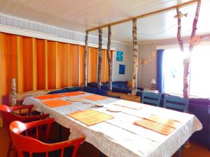 uma sala de jantar com uma mesa com cadeiras vermelhas em Skogsro Forest Hostel em Steinsholt
