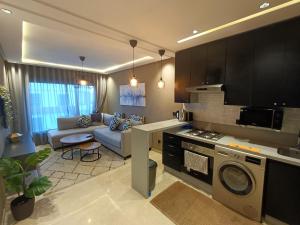 a kitchen and living room with a couch and a stove at Studio Cosy Haut Standing in Casablanca