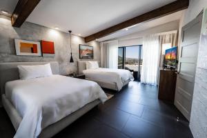 Cette chambre comprend deux lits et une télévision. dans l'établissement Sanctuary Camelback Mountain, A Gurney's Resort and Spa, à Scottsdale