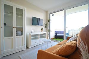 sala de estar con sofá y TV en Apartamento con vistas al Náutico de San Vicente en O Grove