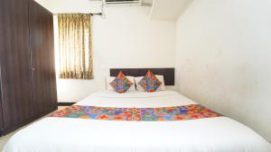 a bedroom with a large white bed with two pillows at Honey Residency Airport Codissia stay in Coimbatore