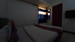 a small bedroom with a bed and a window at Honey Residency Airport Codissia stay in Coimbatore