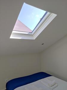 een slaapkamer met een raam in het plafond bij Central Sesimbra 26 in Sesimbra