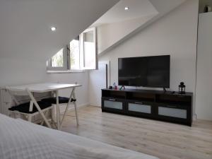 a bedroom with a television and a table and a bed at Central Sesimbra 26 in Sesimbra