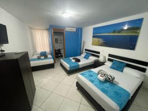 um quarto com duas camas e uma grande pintura na parede em Hotel Miami Beach San Jerónimo em San Jerónimo