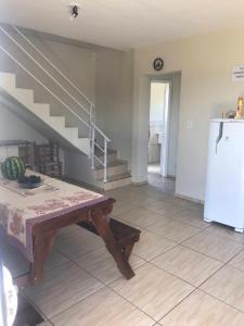 eine Küche mit einem Tisch, einem Kühlschrank und einer Treppe in der Unterkunft Casa Água Azul in Machadinho