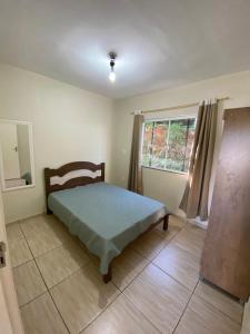Schlafzimmer mit einem Bett und einem Fenster in der Unterkunft Casa Água Azul in Machadinho