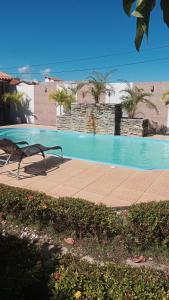 a bench sitting next to a swimming pool at Casa de Praia em Lagoa do Pau Coruripe in Coruripe