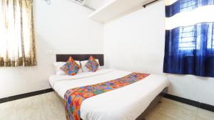 a bedroom with a large bed with a colorful blanket at Honey Residency Airport Codissia stay in Coimbatore