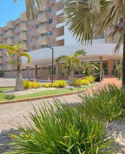 a building with a courtyard with palm trees and plants at Gran Lençóis Flat Residence in Barreirinhas