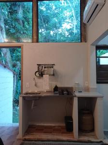 a kitchen with a counter and a large window at Pousada Sobre A Rocha in Praia de Araçatiba