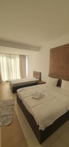 a bedroom with two beds and two windows at E & P HOTEL in Tetovo