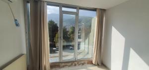 an empty room with a large window with a view at E & P HOTEL in Tetovo