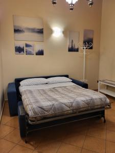 a bed in a room with pictures on the wall at Il Gelsomineto dell'Etna in Nicolosi