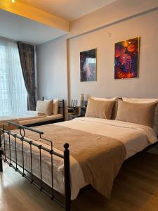 een slaapkamer met 2 bedden en een bank bij TAKSİM SqUARE PARK HOTEL in Istanbul