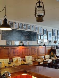 a restaurant with tables and chairs and pictures on the wall at B&B Restaurant Le Pernollet in Evionnaz