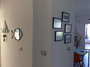 a hallway with a white door with pictures on the wall at Iris Apartments in Vlorë