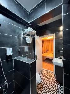 een zwarte badkamer met een wastafel en een toilet bij TAKSİM SqUARE PARK HOTEL in Istanbul