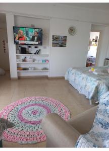 - un salon avec une télévision et un tapis dans l'établissement Ambiente y Medio, à Mar del Plata