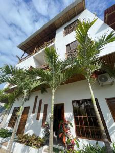 un edificio con palmeras delante en Habitación matrimonial con vista al mar-wanderlust, en Santa Elena