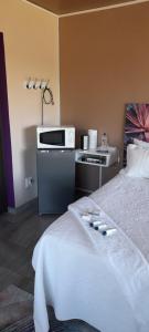 a hotel room with a bed and a microwave at S & V Accommodation in Cape Town