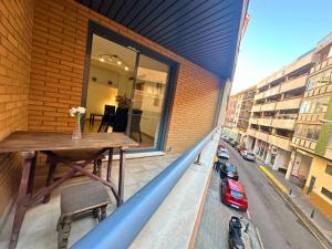 uma varanda com uma mesa de madeira num edifício em Apartamentos Dos Torres Gandalf - Excelente ubicación centrica con garaje incluido em Zaragoza