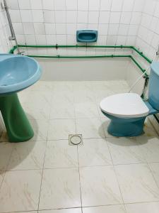 a bathroom with a toilet and a sink at Big bedroom in apartment sharing washroom in Sharjah