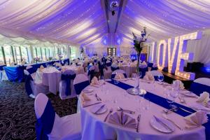 a large banquet hall with white tables and chairs at The Villa Levens in Levens
