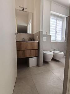 een badkamer met een wastafel, een toilet en een spiegel bij Appartamento Casa Alice in Omegna