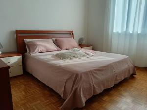 1 dormitorio con 1 cama grande con almohadas rosas en Appartamento Casa Alice en Omegna