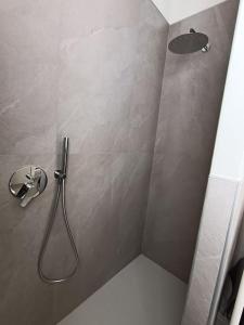 y baño con ducha y cabezal de ducha. en Appartamento Casa Alice, en Omegna