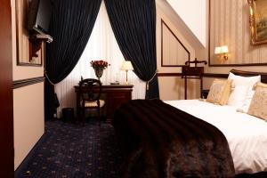 デュッセルドルフにあるHotel Villa Achenbachのベッドとデスクが備わるホテルルームです。