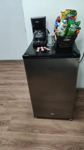 a black refrigerator with a basket on top of it at Hotel a resting place 1 AEROPUERTO in Bogotá
