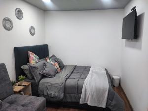 sypialnia z łóżkiem i kanapą w obiekcie Hotel a resting place 1 AEROPUERTO w mieście Bogota
