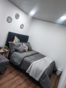 1 dormitorio con 1 cama y 1 sofá en Hotel a resting place 1 AEROPUERTO, en Bogotá