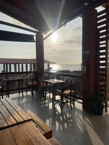 un patio con mesas y sillas y el océano en Habitación matrimonial con vista al mar-wanderlust, en Santa Elena