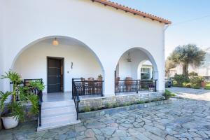a white house with arches and a patio at Villa INVA Korfu in Kavos