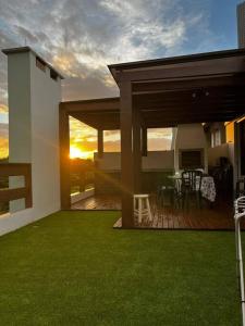 een huis met een terras met een tafel en stoelen bij Cobertura com Vista para o Mar in Florianópolis