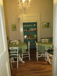 ナポリにあるBed and Breakfast Speranzellaのダイニングルーム(テーブル2台、椅子、シャンデリア付)