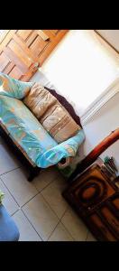 małe łóżko w pokoju z oknem w obiekcie Fullmoon Guasacate House w mieście Popoyo