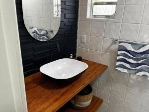 uma casa de banho com um lavatório branco e um espelho. em Cobertura com Vista para o Mar em Florianópolis