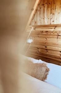 ein Schlafzimmer mit einem Bett mit einer Holzwand in der Unterkunft Kleines Chalet im Erzgebirge mit Sauna und Kamin in Rechenberg-Bienenmühle