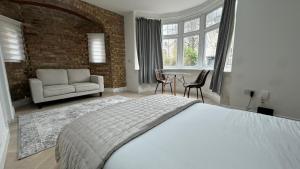 a bedroom with a bed and a couch and a table at London Studios and Suites in Harrow