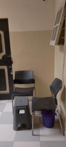 2 sillas y un banco en una habitación en Guest bidossessi, en Abomey-Calavi