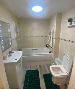 een badkamer met een bad, een toilet en een wastafel bij Mada Apartment Bournemouth 12 min walking to the beach in Bournemouth