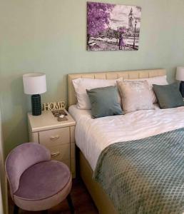 een slaapkamer met een bed, een stoel en een foto bij Mada Apartment Bournemouth 12 min walking to the beach in Bournemouth
