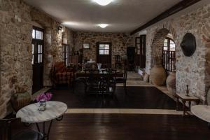 a room with stone walls and a table and chairs at Belessi's Mansion 1 in Monemvasia