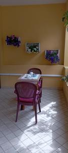 een tafel en stoelen in een kamer met bloemen bij Affittacamere Casa del Sole in Cala Gonone