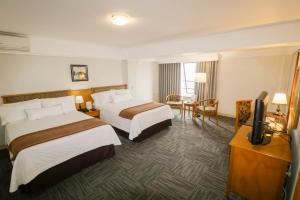 Habitación de hotel con 2 camas y TV de pantalla plana. en Hotel Miramar en Lima