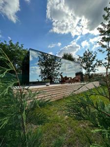 a glass house on top of a wooden wall at Perspective Mirror House in Kocaeli